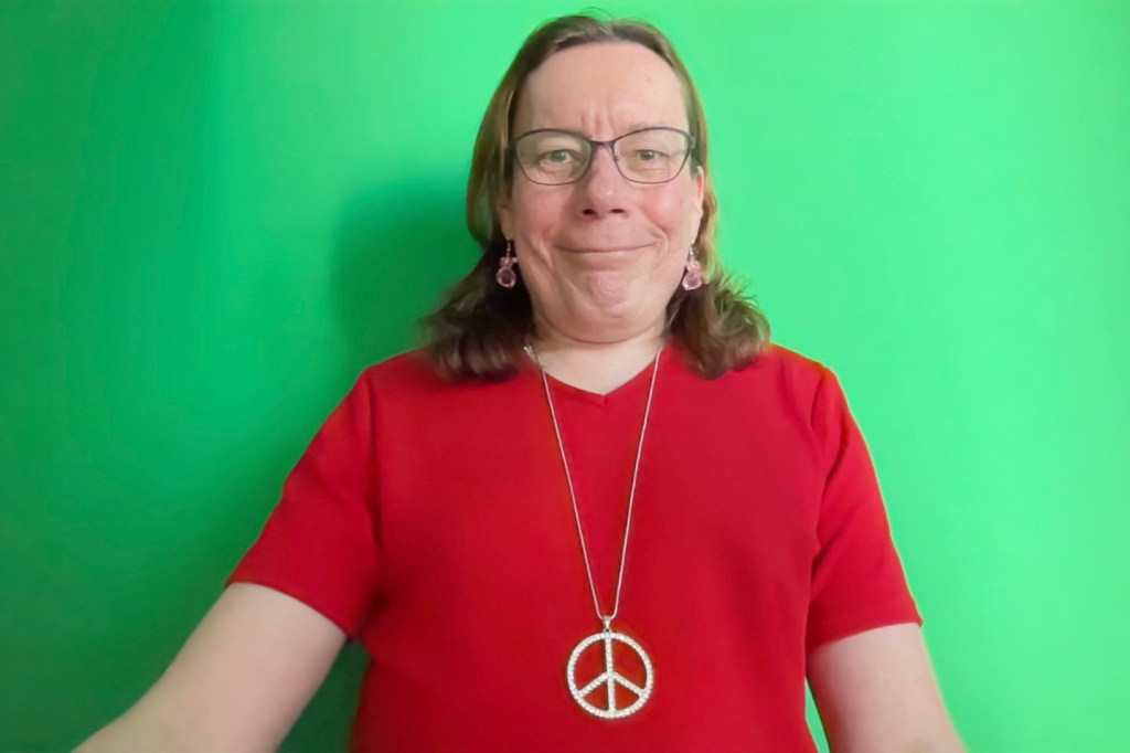 Smiling Mai in front of green screen.